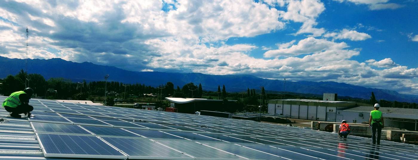 Cuadrilla en el techo de la planta fotovoltaica de 20 kWp de Andreu, Mendoza, con la cordillera de fondo