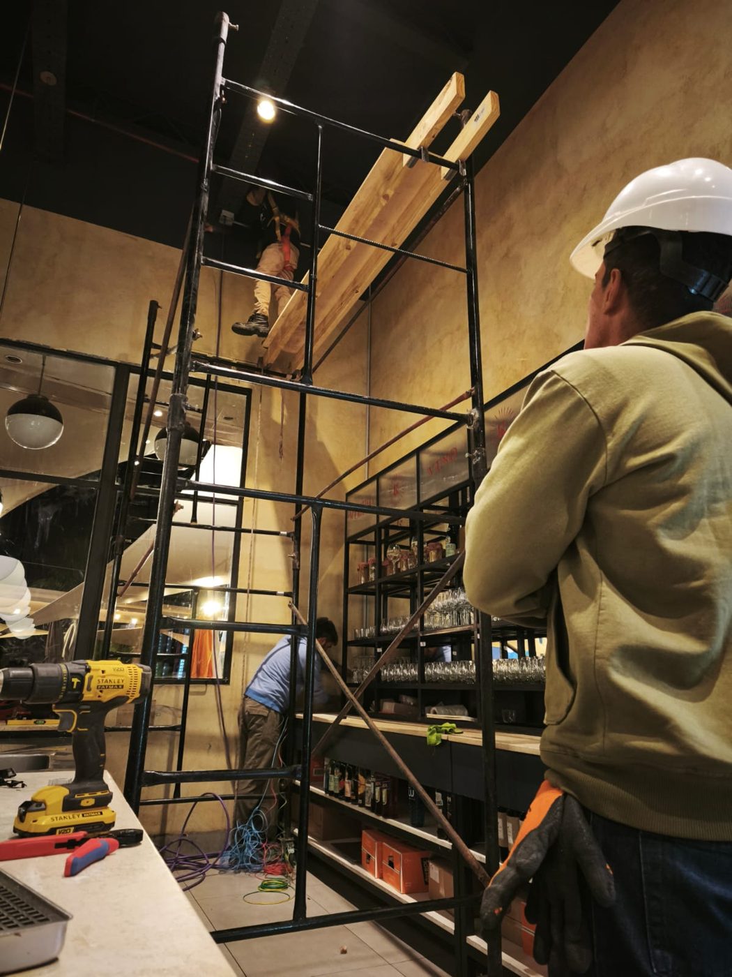 Técnico de Suntec con casco trabajando en altura sobre andamio en el restaurante Nipoti